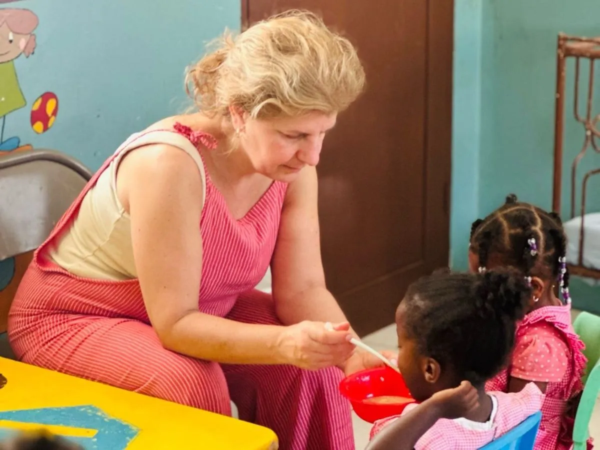 An image showing adult women supervising young children in a colorful classroom setting, illustrating activities within volunteer abroad programs for adults.