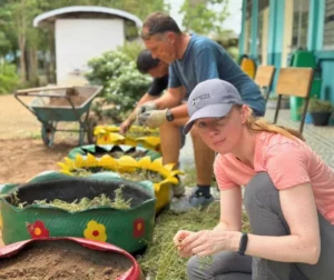 Family volunteering together at a community project in Thailand with local children.